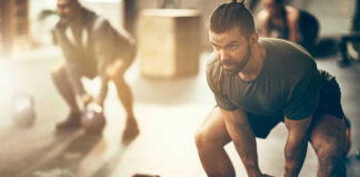 Man lifting kettlebell in a gym setting