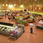 Interior of a grocery store filled with fresh produce and shoppers