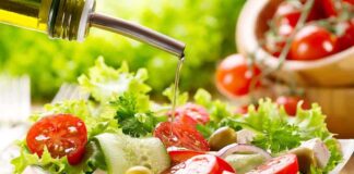 Fresh salad being drizzled with olive oil