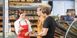 A grocery store employee assisting a couple with their shopping
