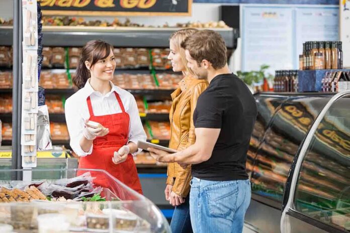 shutterstock_167509160.jpg A grocery store employee assisting a couple with their shopping