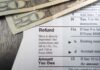 Close up of tax refund form with cash on a wooden surface