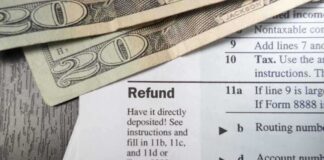 Close up of tax refund form with cash on a wooden surface