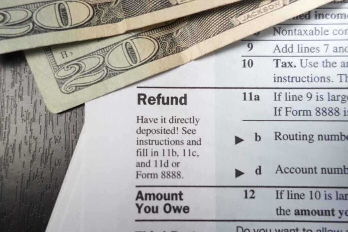 shutterstock_173624585.jpg Close up of tax refund form with cash on a wooden surface