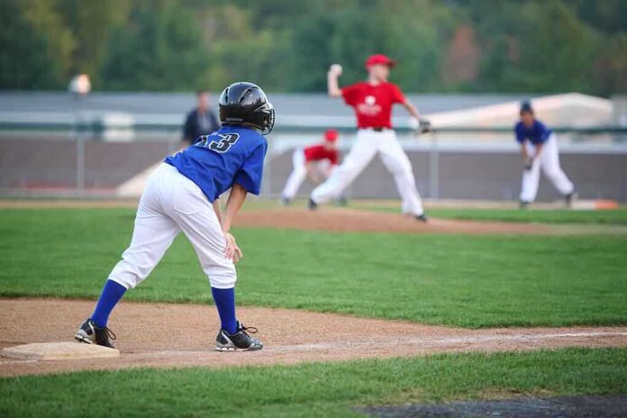 shutterstock_177056369.jpg Young baseball player in blue uniform preparing to run on the field