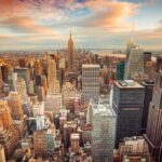 Aerial view of New York City skyline during sunset with skyscrapers and clouds