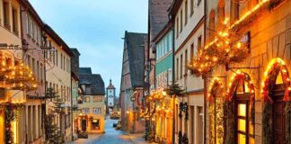 A picturesque street adorned with holiday lights and decorations in the evening