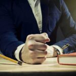 Elite’s Bizarre Success Pattern DISCOVERED A man's clenched fist resting on a desk with office supplies nearby