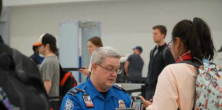 TSA agent checks passengers documents at airport security