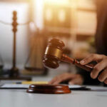 Hand holding gavel with scales in background