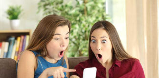 Two women look surprised at a phone