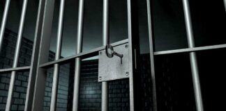 Close up of a locked prison gate with metal bars