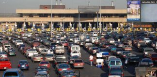A crowded parking lot filled with cars near a border crossing