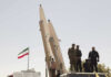 Protests Erupt: Iran’s Supreme Leader on the Run? Military personnel beside missiles and Iranian flag.