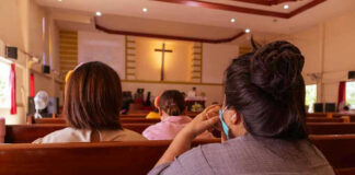 People sitting in church pews during service.