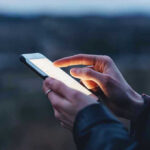 Person using a smartphone at dusk.