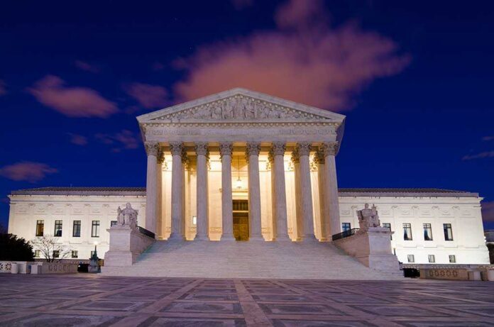 The Supreme Court building illuminated at night with a clear sky