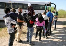 650 ICE Arrests Shock West Virginia Families and children waiting in line near a bus