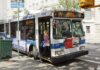 A woman boarding a clean air hybrid electric bus at a city stop