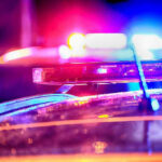 Close-up of police car lights flashing at night.