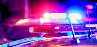 Close-up of police car lights flashing at night.