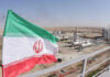Trump REJECTS Ceasefire — Regime on the Brink Iranian flag near an industrial gas refinery.