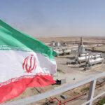 Trump REJECTS Ceasefire — Regime on the Brink Iranian flag near an industrial gas refinery.