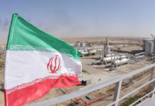 Iranian flag near an industrial gas refinery.