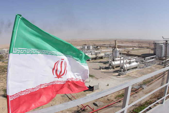 Iranian flag near an industrial gas refinery.