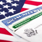 Green Cards Yanked—Iran Regime Families Nabbed Social Security card and green card on flag.