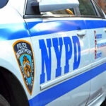 NYPD Sergeant CAGED For Stopping Gang Threat NYPD police car with logo and text.