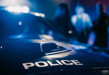 Police car with blurred figures in the background.