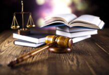 A gavel, legal books, and scales of justice on a wooden table