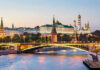 Kremlin’s Mixed Messages! Is Peace a Mirage? Illuminated bridge and Kremlin complex across river at twilight.