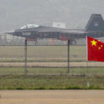 Jet with 31001 marking behind barbed wire fence.