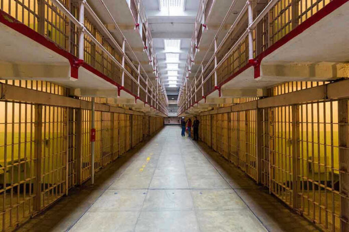 372127549 Long hallway with prison cells on both sides.