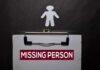 Clipboard with a missing person notice and a paper cutout figure