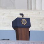 Podium with a microphone and presidential seal in front of steps