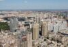 Aerial view of a sprawling urban city with high-rise buildings and green spaces