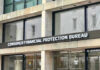 Cartel Cash Choked — Banks on Notice Consumer Financial Protection Bureau building entrance sign.