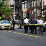 Festival Chaos: Gunmen Vanish Into Crowds Police gathered at an urban crime scene.