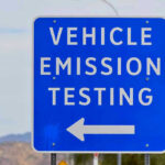 Diesel Mechanic Pardoned—Regulators Rattled Blue sign for vehicle emission testing direction.