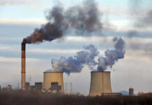 Industrial plant emitting black smoke into the sky.