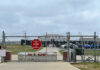 Base Breach Sparks Fentanyl Panic Chain-link fence with Restricted Area Stop No Photography sign.