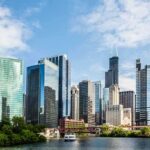 Bloody Chicago Weekend- Showdown Explodes Chicago skyline featuring modern skyscrapers along a river