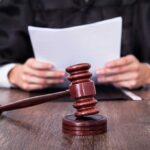COVID Psychosis Defense Frees Child Killer A judge holding documents with a gavel in the foreground
