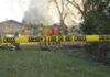 Fiery Skydiving Crash—Washington Locks Down Answers Yellow police tape marking a restricted area at a fire scene with firefighters in the background