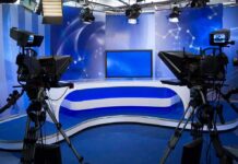 Vance Shreds ‘Instant Oil Money’ Spin On-Air A television studio setup with cameras and a blue backdrop