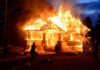 National Guard Rushed Into Firestorm House engulfed in flames with firefighters present.