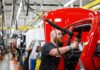 White-Collar Purge At BMW Worker assembles red vehicle on factory line